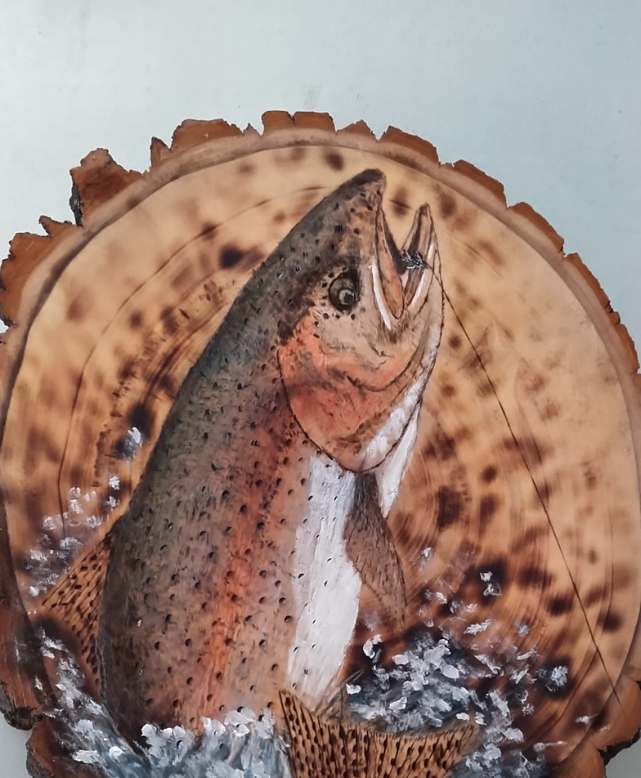 Pyrography of a trout getting fished by Dennis Lampela